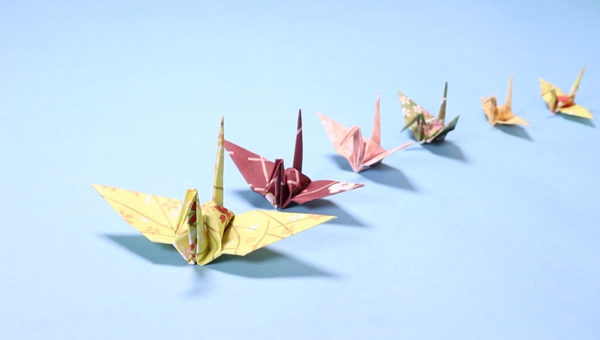 Paper crane on blue background