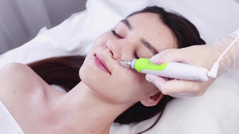 Fractional mesotherapy. A young woman in the cosmetologist’s office receives fractional mesotherapy for her face. Rejuvenation of the skin of the face. Acne treatment.Hardware cosmetology.Beautician.