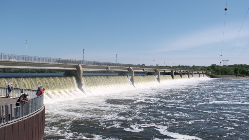 People fishing in front of a hydroelectric dam