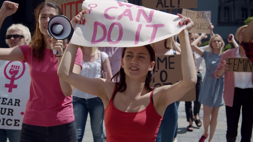 Active feminists resistance crowd of young strong women rebelling on street demonstration protesting for equal rights. Feminism promotion. Gender politics. | Shutterstock HD Video #1055713601