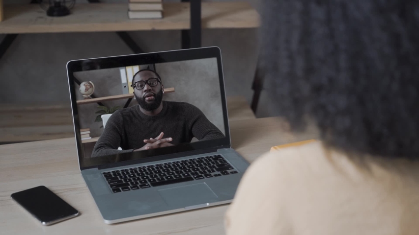 african american woman with curly hair holds video conference calling to black man, online on laptop computer at home\office. Elearning zoom app video call, distance videoconference Royalty-Free Stock Footage #1055732018