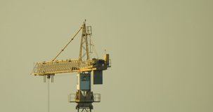 
A beautiful video in which the tap is spinning. Yellow crane on sky background close up.