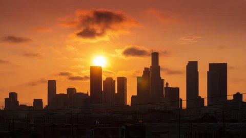 Beautiful sunset sun setting behind downtown Los Angeles city skyline. 4K UHD Timelapse.