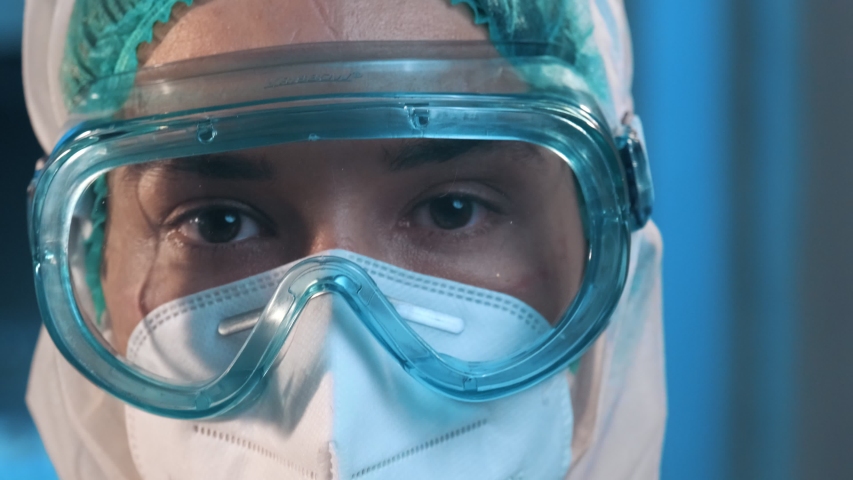 Female doctor during a coronavirus pandemic covid-19 takes off glasses and a protective mask after a shift in the hospital, and shows the wounds rubbed with protective mask, red spots. Tired nurse Royalty-Free Stock Footage #1055746760