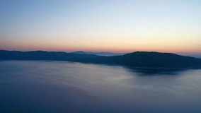 FHD video aerial view of a lake with sunrise and silhouette hill background. Travel Tourism concept.