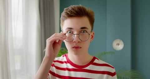Young man shocked and surprised. A male in surprise take off glasses and looks at the camera.