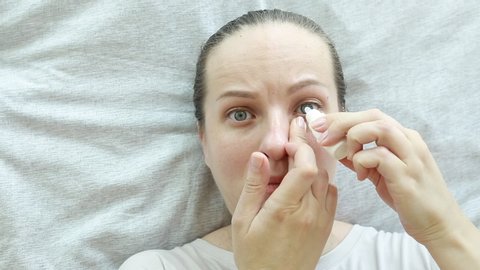 A woman uses eye drops. Allergy. Eye problems.