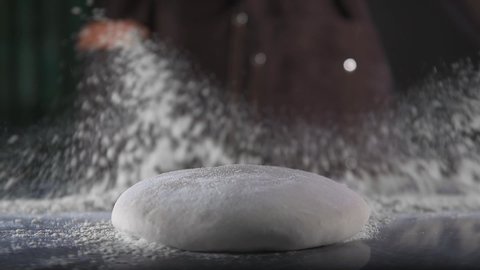 Chef drops dough on flour
