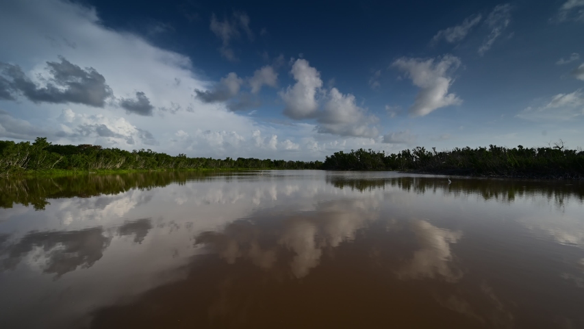 Timelapse of clouds reflected on Eco Pond in Everglades National Park, Florida on sunny summer morning.