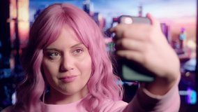Pink-Haired Party Girl Takes Selfies on Smart Phone with Colorful Sci-Fi Scene in Background