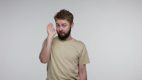 You are idiot, cuckoo out of mind! Bearded man gesturing finger against temple doing stupid gesture and pointing to camera, mocking, looking displeased with crazy idea. indoor studio shot isolated