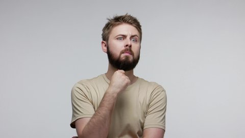 Pensive confused guy leaning hand, rubbing beard while thinking over difficult choice, imagining plan in mind, having doubts, pondering idea looking puzzled clueless. indoor studio shot isolated
