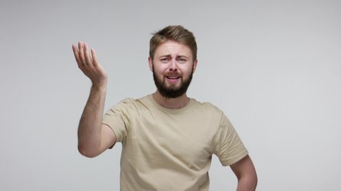 Unhappy bearded man slapping hand on forehead, doing facepalm gesture, looking at camera sorrow regret, pointing you blaming for mistake failure. indoor studio shot isolated on gray background