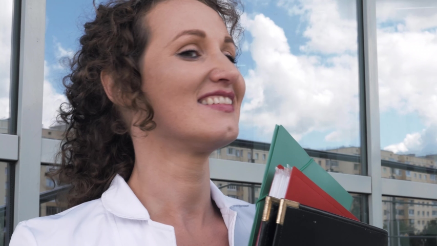  Smiling attractive young adult woman model looking at camera, happy beautiful 30s brunette lady professional pretty face dental smile posing stand alone indoors, slow motion close up view portrait