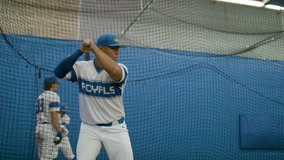 Athletic baseball player practicing his swing in a training facility. Batting cage in slow-motion and shot in 4k.  - Powered by Shutterstock - Get 15% off with code: PIKWIZARD15