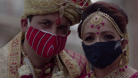 Indian bride and groom at their Lockdown marriage, during coronavirus outbreak. Bride & groom wearing protective mask against COVID-19.