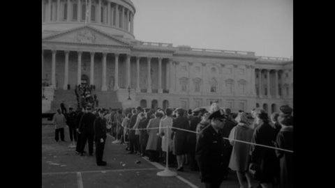 CIRCA 1963 - Huge crowds of servicemen and civilians are lined up outside the Capitol Building in Washington DC to see JFK's casket.