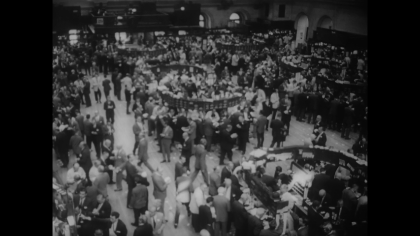 CIRCA 1962 - Men make calls and put in orders on the floor of the New York Stock Exchange in Manhattan, New York.