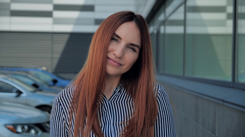 Close up portrait of an attractive red-haired woman opening her green eyes and smiling 4k