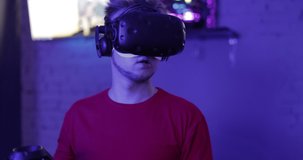 The guy is playing virtual reality games. Neon room for cyber sports. Cyberpunk games. High quality 4k footage