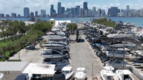 4K aerial view on an elevator truck at the marine boat club parking. Beautiful slow motion drone video for yacht business. Marine club with Miami downtown on background. Water sport and transportation