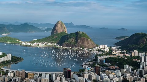 Rio de Janeiro, Brazil, zoom out timelapse view of Rio cityscape including natural landmark Sugar Loaf Mountain and Guanabara Bay at sunset.