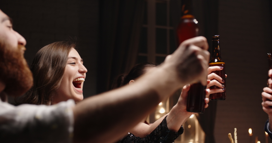 Group of happy multiethnic friends having fun together, drinking bottled beer in a bar or at home, celebrating, happily smiling - friendship, togetherness concept 4k footage | Shutterstock HD Video #1055858267