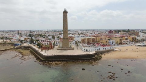 Aerial view. The highest lighthouse on the coast is that of Chipiona on the Atlantic in Andalusia. The drone flies a quarter circle to the left and shows the city and the southern coast.