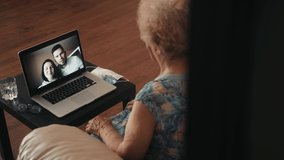 Cheerful old eldery woman talking camera video conference on laptop, calling from home with family. Young couple video chat with grandmother, home isolation, distance during coronavirus covid pandemic