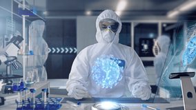Male Scientist analyzing and interacting with a 3D Rotating Coronavirus Virus Cell Hologram in a Secure High Level Modern Laboratory. Genetic Engineering Research Facility. Pandemic Research. - Powered by Shutterstock - Get 15% off with code: PIKWIZARD15