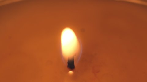 beautiful fire of a candle in a dark room, a warm yellow candle