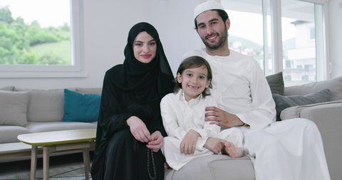 Muslim family together on the sofa before iftar dinner during a ramadan feast at home