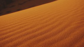 Close-up of wind blows sand in the desert of sand dunes in the Sahara desert at sunset, sun bunnies into camera, 4k
