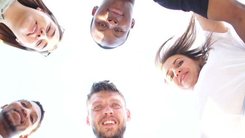 Close portrait of five young students, tolerance and no racism concept. Interracial group of students leaned over the camera against the sky Royalty-Free Stock Footage #1055901677