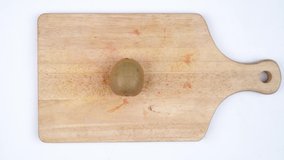 Stop motion of ripe kiwi peeled while slicing on the cutting board with isolated on white background. Shot in 4k resolution