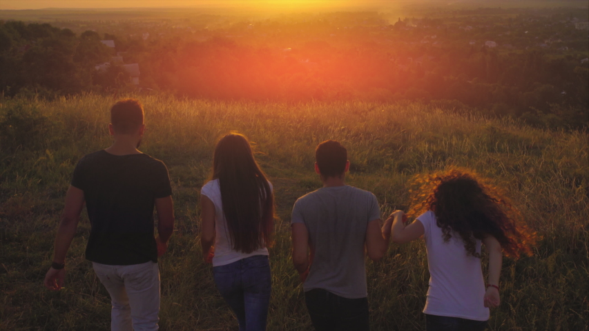The four young people meeting sunrise on the hill. | Shutterstock HD Video #1055912063