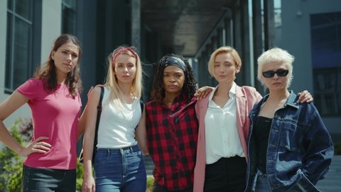 Team of independent beautiful multi-ethnic women posing together on street. Girl power concept. Human and gender equality. Feminists. Promotion of feminism.