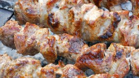 Sliced pieces of meat on a skewer. Pork skewers on the grill. Sliced meat with melting fat close up view in the garden of a country house