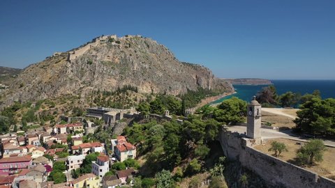 Aerial drone rotational video from medieval old clock tower in Acronafplia castle overlooking historic and picturesque fortress of Palamidi in old town of Nafplio, Argolida, Peloponnese, Greece