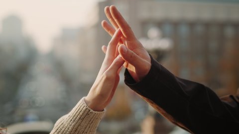 Love couple hands connecting in urban background. Unrecognizable man and woman hands holding outdoors. Closeup romantic people touching hands outside.