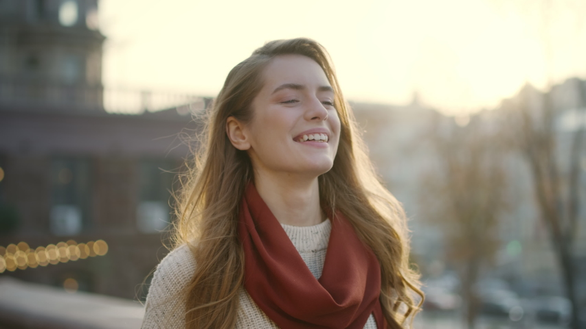 Portrait of sweet hipster girl smiling on city street. Closeup cheerful woman walking outdoors in slow motion. Happy woman enjoying day in urban background. | Shutterstock HD Video #1055931398