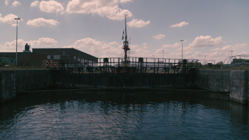 revealing an old red lighthouse boat that lies in an abandoned shipyard on a sunny day. 