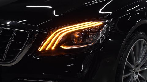 Close up of details of headlights of anonymous prestigious black luxury modern car. Concept of passion for driving cars, car dealerships,luxury cars. Shot in 4K. Head light