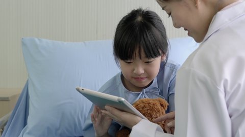 Asian doctor nurse pediatrician woman visiting child girl patient and empathy to the diagnosis when visit doctor. Concept of medical, healthcare, healthy family, pediatric checkup and hospital office.