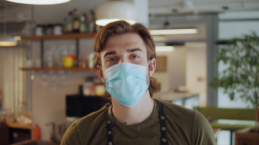 cafe or restaurants and business reopen after coronavirus quarantine is over. portrait of man with face medical mask, owner barman. small business post covid lockdown. Royalty-Free Stock Footage #1055936822