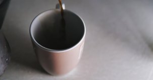 Pouring black coffee in cup. Espresso coffee using turkish coffee maker