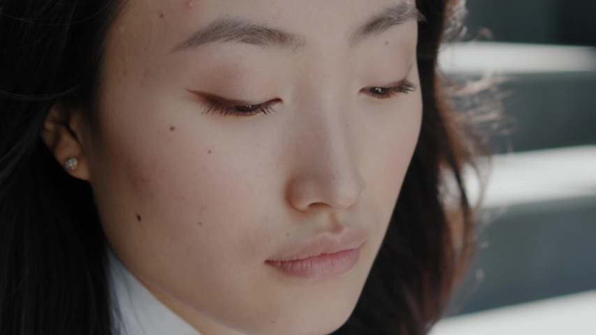 Face of beautiful soft chinese woman with natural make-up looking at camera. Portrait young asian pretty brunette girl outside at sunshine. Etnnicity. People. Beauty.