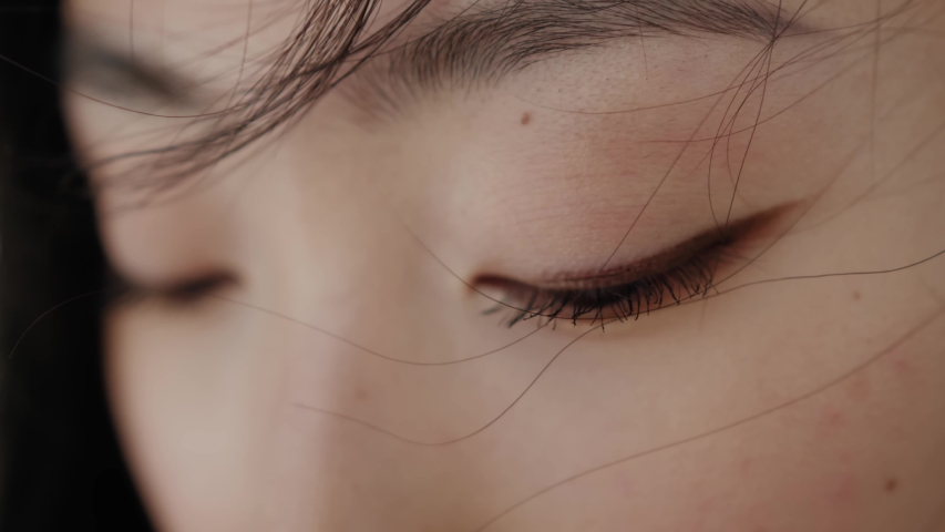 Eyes of wonderful asian young woman opening and looking straight. Beautiful face of chinese sensitive lady outdoors. Ethnicity. Close-up.