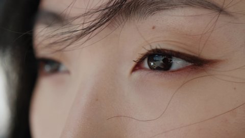 Eyes of wonderful asian young woman opening and looking straight. Beautiful face of chinese sensitive lady outdoors. Ethnicity. Close-up.