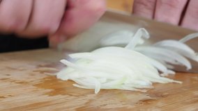 the cook cuts onions on a wooden Board. 4K video